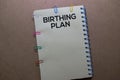 Birthing Plan write on Book. Isolated on office desk background