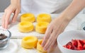 Biscuit cakes with fresh berries, chocolate, and whipped heavy cream. Woman preparing dessert