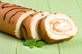 Biscuit swiss roll close-up on green wooden background