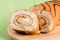 Biscuit swiss roll close-up on green wooden background