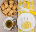 Biscuits in basket, hot tea, lemon, sugar cubes and knife Royalty Free Stock Photo