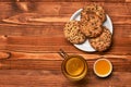 Biscuits with seeds placed near cup of tea and honey Royalty Free Stock Photo