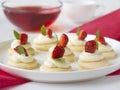 Biscuits with whipped cream, strawsberry, mint on white plate on table against light background Royalty Free Stock Photo