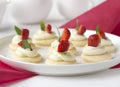 Biscuits with whipped cream, strawsberry, mint on white plate on table against light background Royalty Free Stock Photo