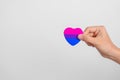 Bisexuality Celebrate Day and LGBT pride month, LGBTQ+ or LGBTQIA+ concept. Hand holding purple, pink and blue heart shape for