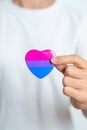 Bisexuality Celebrate Day and LGBT pride month, LGBTQ+ or LGBTQIA+ concept. Hand holding purple, pink and blue heart shape for