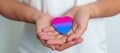 Bisexuality Celebrate Day and LGBT pride month, LGBTQ+ or LGBTQIA+ concept. Hand holding purple, pink and blue heart shape for