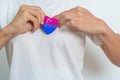 Bisexuality Celebrate Day and LGBT pride month, LGBTQ+ or LGBTQIA+ concept. Hand holding purple, pink and blue heart shape for