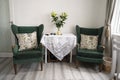 Bishop, Auckland, U.K. 27 July, 2021. Living room with two old, vintage green velvet armchair and table with flowers. Interior Royalty Free Stock Photo