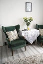 Bishop, Auckland, U.K. 27 July, 2021. Living room with two old, vintage green velvet armchair and table with flowers. Interior Royalty Free Stock Photo
