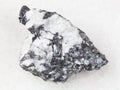 Bismuthinite vein in rough quartz stone on white
