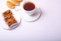 Bisquit cakes, croissants and tea cup on white background