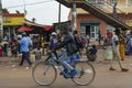 Street scene in the city of Bissau with a man riding his bicycle in front of the Bandim Market, in Guinea-Bissau