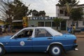 Street scene in the city of Bissau with a taxi and people passing in front of a cyber cafe, in Guinea-Bissau