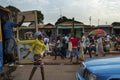 Street scene in the city of Bissau with a woman exiting a mini bus toca toca at the Bandim Market, in Guinea-Bissau