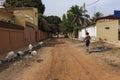 Street scene in the city of Bissau with a young woman walking in a dirt road and goats, in Guinea-Bissau Royalty Free Stock Photo