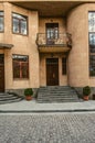 Facade of the house with a niche staircase, windows and a beautiful balcony is covered with openwork wrought iron bars