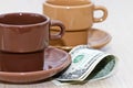 Bit of cash lying under an empty coffee Cup Royalty Free Stock Photo