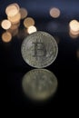Bit Coin reflectin on table, with blured Christmas light Royalty Free Stock Photo