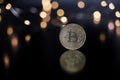 Bit Coin reflectin on table, with blured Christmas light Royalty Free Stock Photo