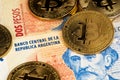 Bitcoin BTC cryptocurrency coins on Argentina money Pesos banknotes. BTC Bitcoin Argentina