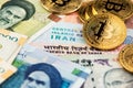 Bitcoin BTC cryptocurrency coins on Iranian and Indian currency banknotes close up image. Royalty Free Stock Photo