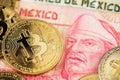 Bitcoin BTC cryptocurrency coins lying on Mexican Pesos currency banknotes. Royalty Free Stock Photo