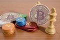 Bitcoin, casino chips and chess on a wood table