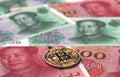 Bitcoin coin on Chinese Yuan bills with copy space on the top. Bitcoin in China concept. 3D rendering