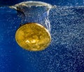 Bitcoin sinking through water as illustration of falling price