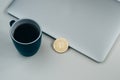 Bitcoin coin near grey laptop and blue coffee cup. Cryptocurrency concept. Isolated on white Royalty Free Stock Photo