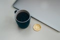 Bitcoin coin near grey laptop and blue coffee cup. Cryptocurrency concept. Isolated on white Royalty Free Stock Photo