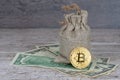 Bitcoin coin over dollar banknotes, full jute sack - rich concept Royalty Free Stock Photo