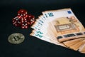 Bitcoin coin, a pile of Euro banknotes and a few red cubes lie side by side on a dark background