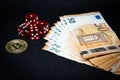 Bitcoin coin, a pile of Euro banknotes and a few red cubes lie side by side on a dark background