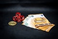 Bitcoin coin, a pile of Euro banknotes and a few red cubes lie side by side on a dark background