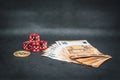 Bitcoin coin, a pile of Euro banknotes and a few red cubes lie side by side on a dark background