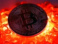 Bitcoin coin on top of red hot burning beats Royalty Free Stock Photo