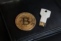 Bitcoin coin and USB flash drive in the form of a metal key on a black leather wallet. Cryptocurrency storage concept, Royalty Free Stock Photo