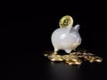 Bitcoin coins are on the back of a white piggy bank. on a black background Royalty Free Stock Photo