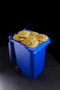 Bitcoin coins in the blue trash on black