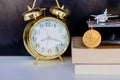 Bitcoin coins on book alarm clock old gold and model of passenger plane over white black background