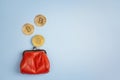 Bitcoin coins falling in red money purse on blue background. Co Royalty Free Stock Photo