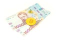 Bitcoin coins new virtual money on Ukraine banknotes close up image of bitcoins with Ukraine hryvnia banknotes. Bitcoin Royalty Free Stock Photo