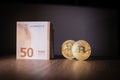 2 Bitcoin coins are next to a bundle of euro banknotes Royalty Free Stock Photo