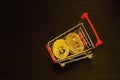 Bitcoin coins in shopping cart. Black background Royalty Free Stock Photo