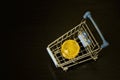 Bitcoin coins in shopping cart. Black background Royalty Free Stock Photo