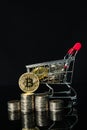 Bitcoin coins in shopping cart on black background Royalty Free Stock Photo