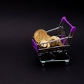 Bitcoin coins in a shopping cart. Virtual cryptocurrency purchase concept. Black background. Bitcoin mining, online business, Royalty Free Stock Photo