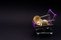 Bitcoin coins in a shopping cart. Virtual cryptocurrency purchase concept. Black background. Bitcoin mining, online business, Royalty Free Stock Photo